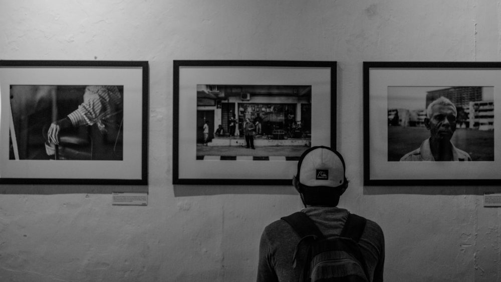 Visitor admiring black-and-white photography in a minimalist setting—exploring the Best Art Galleries in London experience.