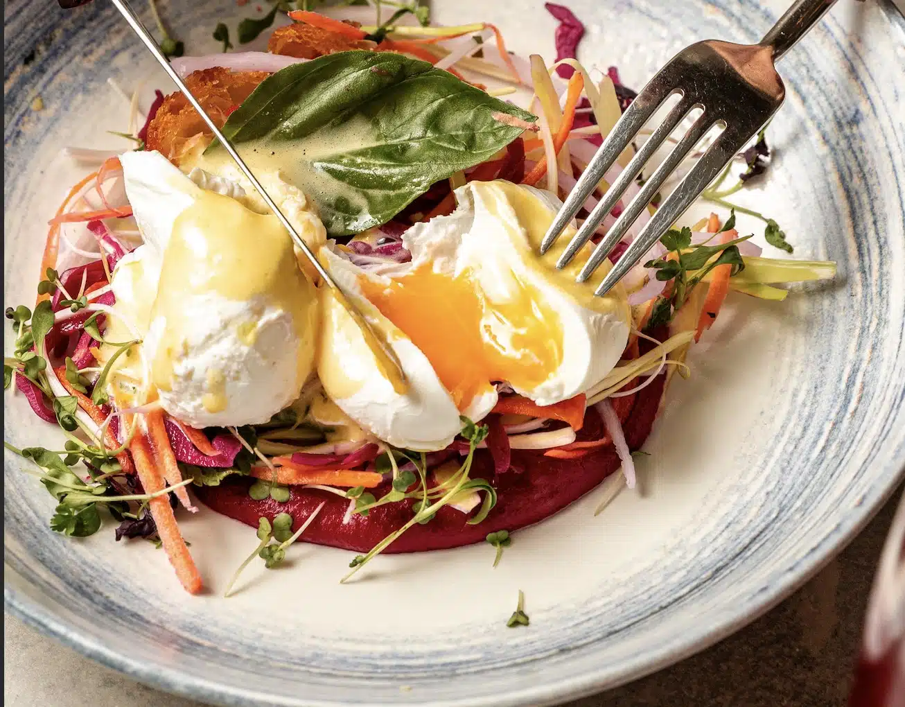 A vibrant dish with poached eggs, fresh veggies, and hollandaise sauce served at Fremantle Bar & Kitchen, perfect for brunch lovers.