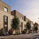 Modern townhouses with brick facades and tree-lined streets at Trinity Park Woolwich, offering serene living spaces in London.