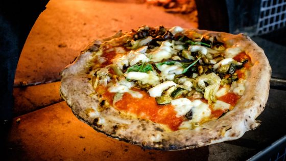 Wood-fired Santa Maria Pizza London, topped with fresh mozzarella, basil, and roasted vegetables, straight from the oven.