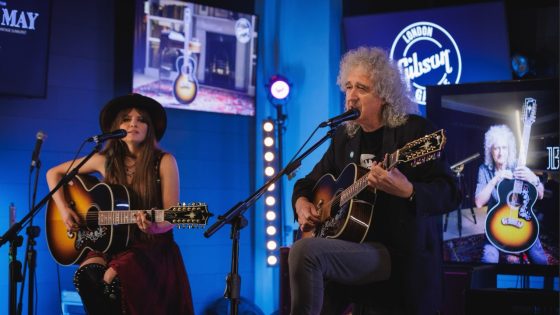 Sir Brian May at Gibson Garage London, performing live with acoustic guitar at an exclusive event.