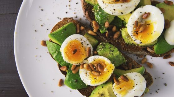 Avocado toast with eggs and pine nuts, a budget-friendly meal option featured in our cheap eats in London guide.