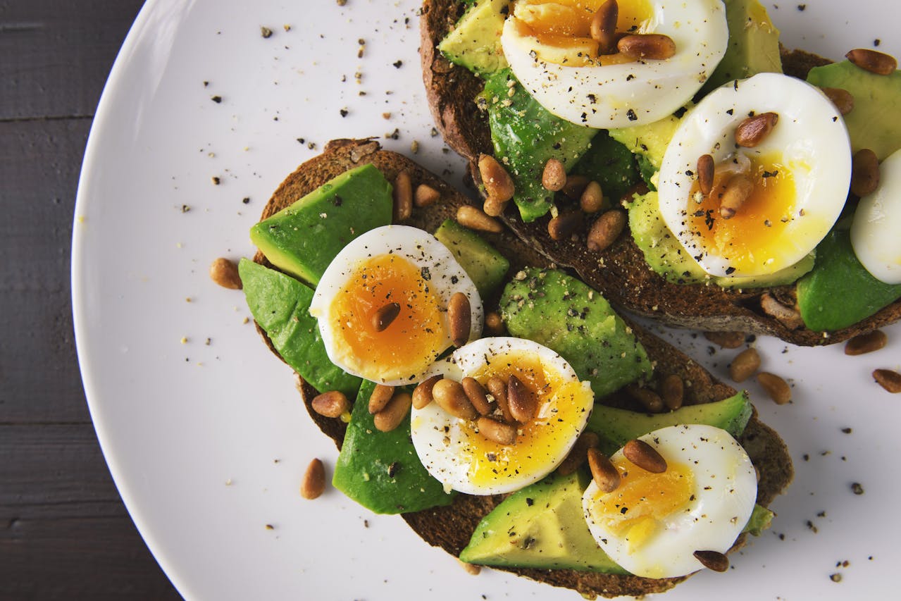 Avocado toast with eggs and pine nuts, a budget-friendly meal option featured in our cheap eats in London guide.