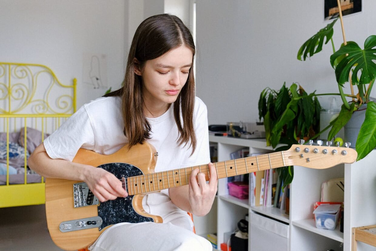 girl playing guitar depicting the unusual hobbies in London