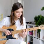 girl playing guitar depicting the unusual hobbies in London