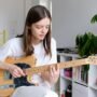 girl playing guitar depicting the unusual hobbies in London